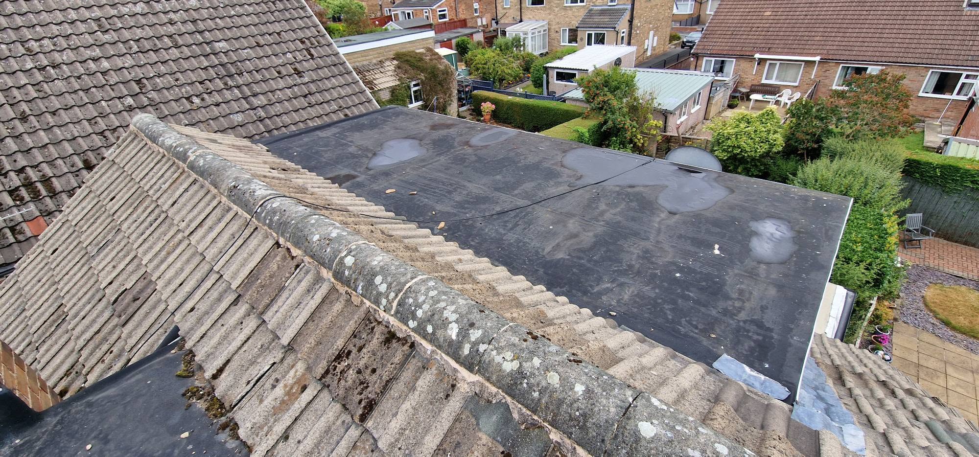 Roofing team fitting tiles on a scaffolded roof during a replacement project
